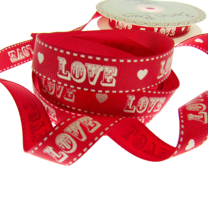 Red ribbon with 'LOVE' and heart patterns on a white background