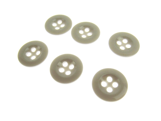 Six four hole white trouser buttons on a white background