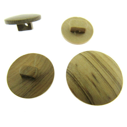 A set of round wooden buttons made from olive trees, displayed in different sizes, showing the natural grain of the wood.