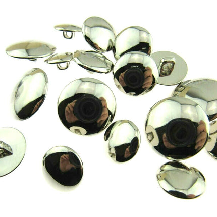 A collection of round, shiny silver plastic blazer buttons with a bevelled top and shank, displayed on a white background.