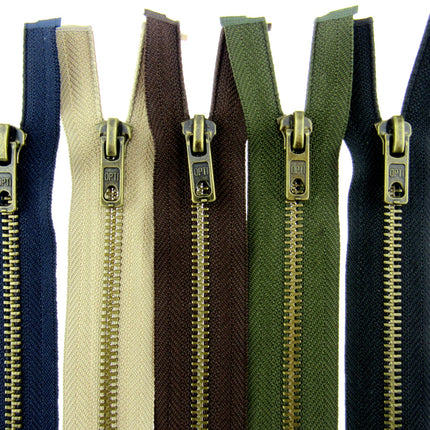 A selection of antique brass metal open end zips in various colors including black, brown, beige, navy, and green, displayed side by side.