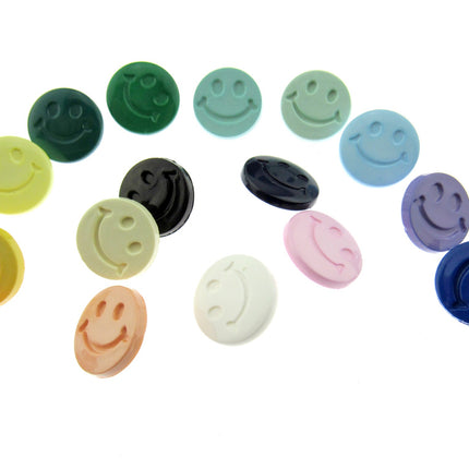 Smiley face buttons in an array of colours on a white background