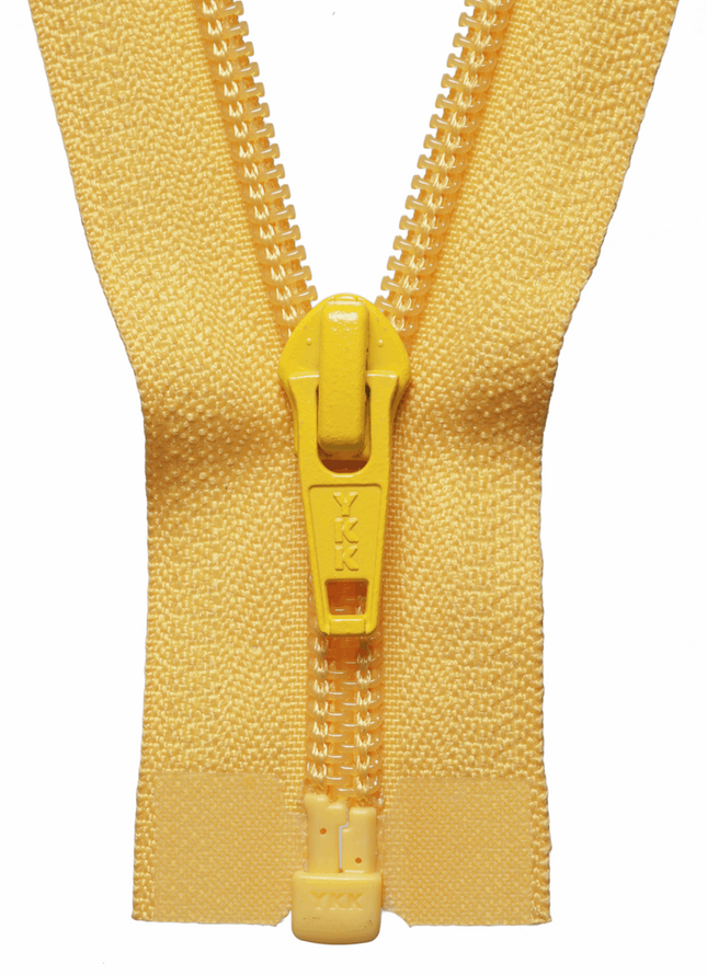 View of a number five YKK nylon coil open end jacket zip showing the five millimetre wide spiral teeth teeth flat next to a tailoring measuring tape.
