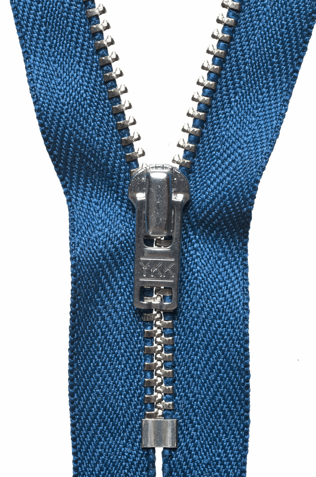 Close up view of heavy duty YKK metal trouser zips showing the brass teeth and autolock slider.